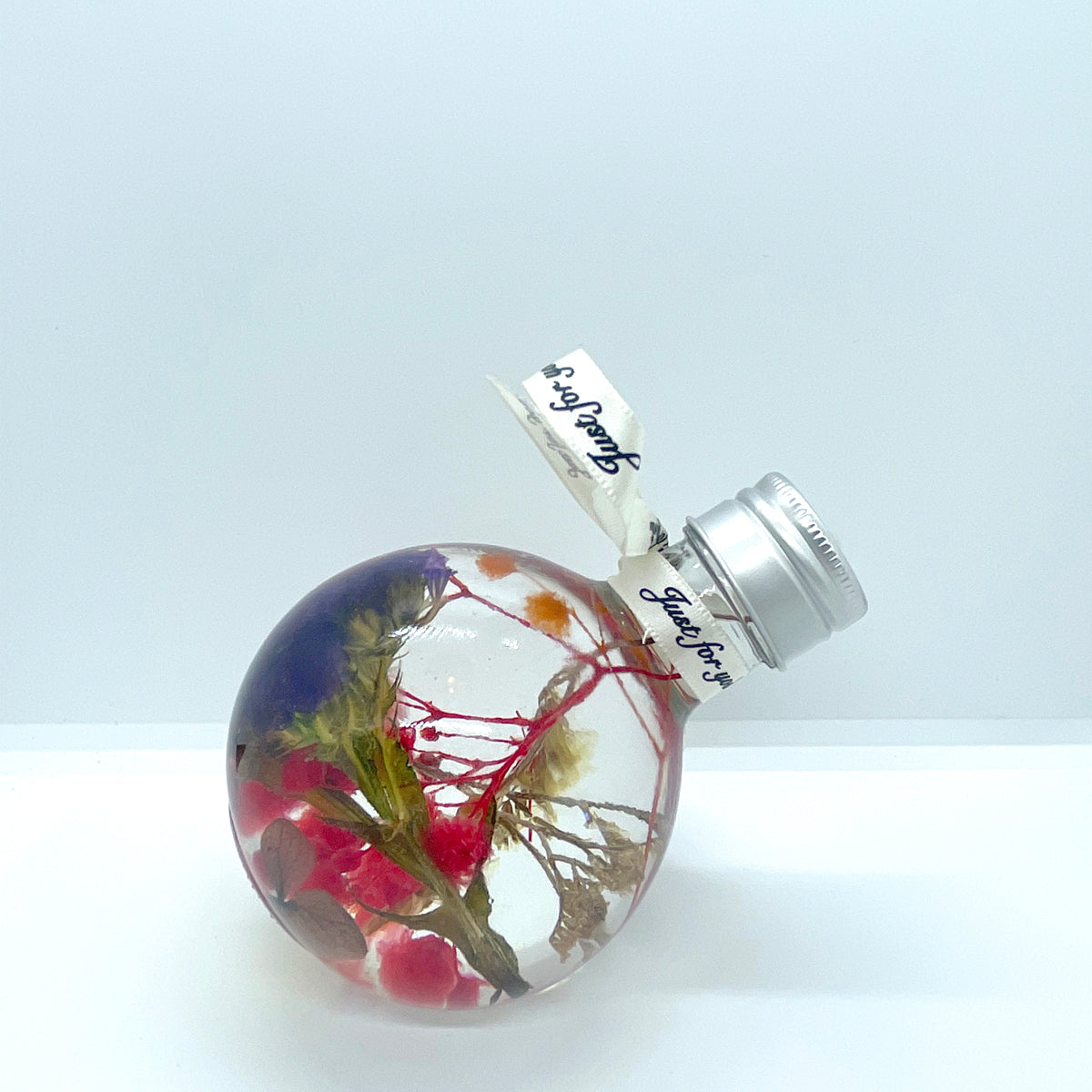 Floating flowers in clear and mixed colors (looking into the bottle shape)