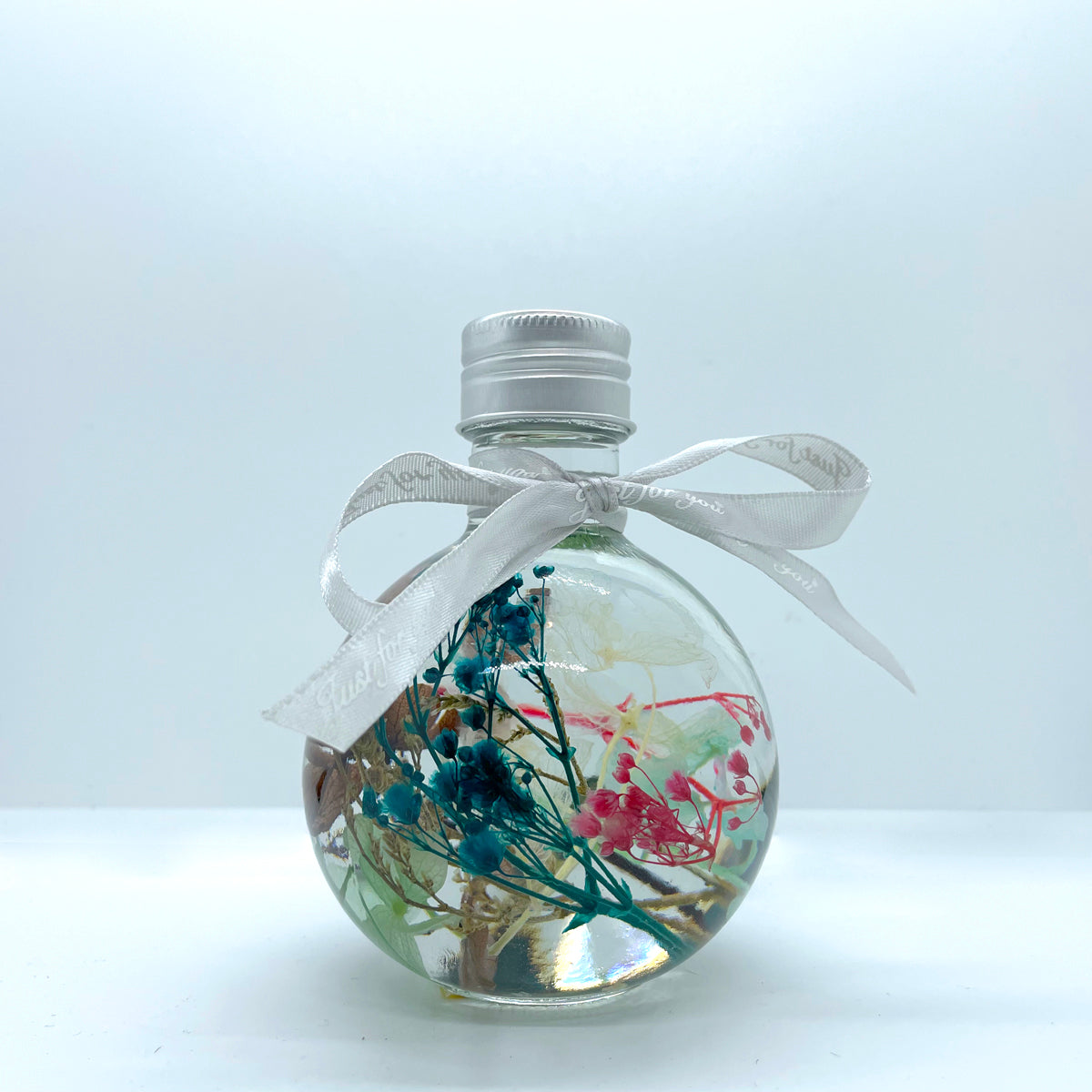Floating flowers in clear and mixed colors (looking into the bottle shape)