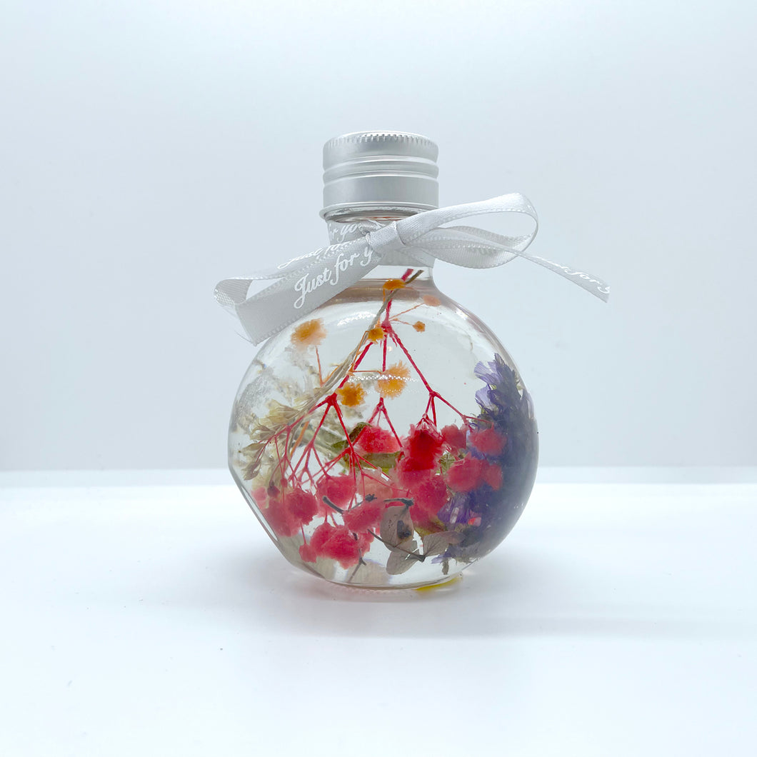 Floating flowers in clear and mixed colors (looking into the bottle shape)